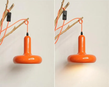 Due lampade a sospensione arancioni appese a parete con cavi decorativi